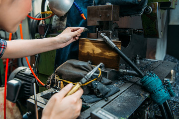 factory staff place parts in milling machine