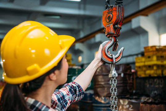 industrial factory woman holding chain crane