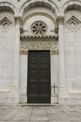Fototapeta na wymiar LUCCA, ITALY- AUGUST 15 2015: Architectural close up of the doorway to San Michele church in Lucca, Italy