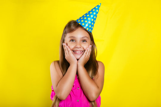 Studio portrait of a little girl wearing a party hat on her birthday