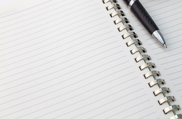 Close up view of note book with silver metal binder and pen with space for text - business background