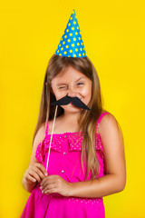 Studio portrait of a little girl wearing a party hat on her birthday