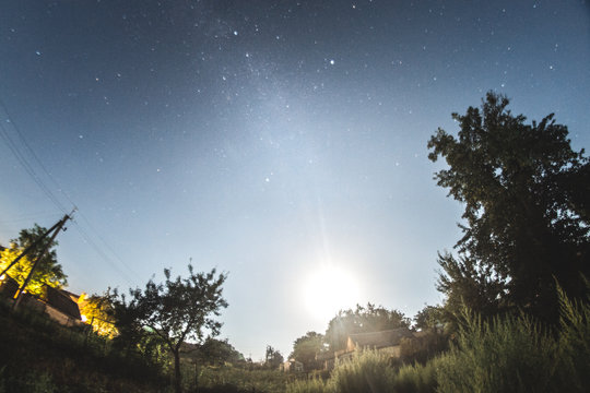 Starry sky in the summer evening over the village.