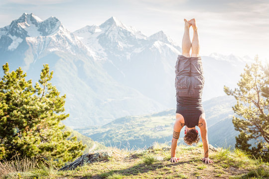 Ragazzo in verticale con panorama di montagna, a testa in giu