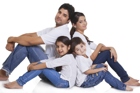 Portrait of happy family sitting over white background 