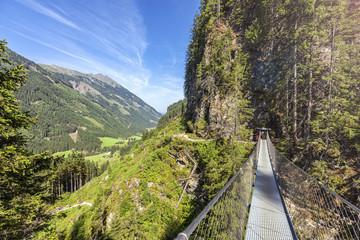 Fototapeta na wymiar Swing bridge over the Riesach waterfall at Rohrmoos Untertal