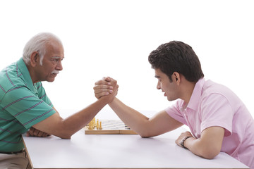 Grandfather and grandson doing arm wrestling