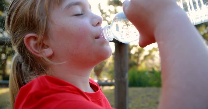 Girl drinking water after workout in boot camp