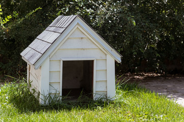White wooden doghouse on a house backyard - obrazy, fototapety, plakaty