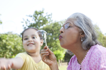 Fototapeta premium Senior woman blowing bubbles
