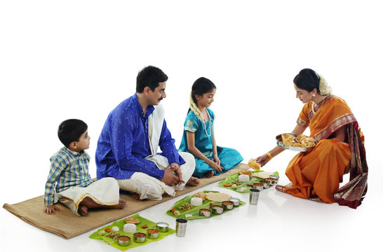 South Indian woman serving food to her family 