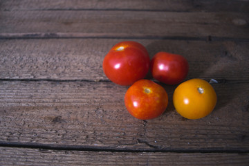 Fototapeta na wymiar Fresh tomatoes on a wooden old background.