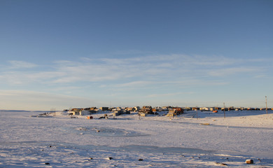 Arctic community of Cambridge Bay in the fall with snow on the ground and blue skies