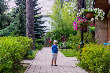 A child looks at a bicycle in the backyard. Landscape design