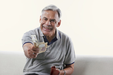Portrait of an old man offering money 