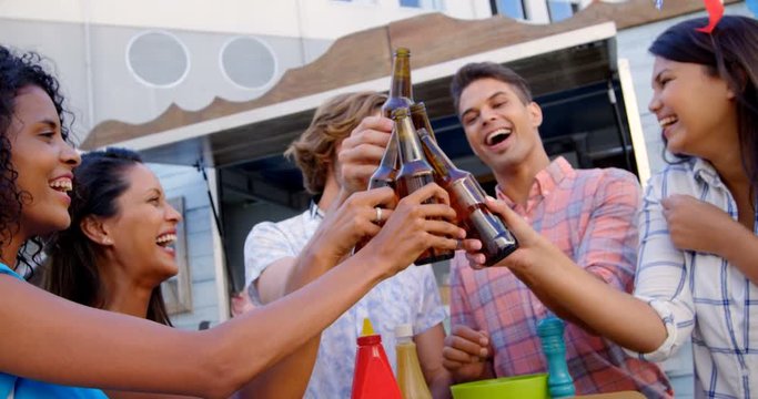 Group of friends toasting beer bottles