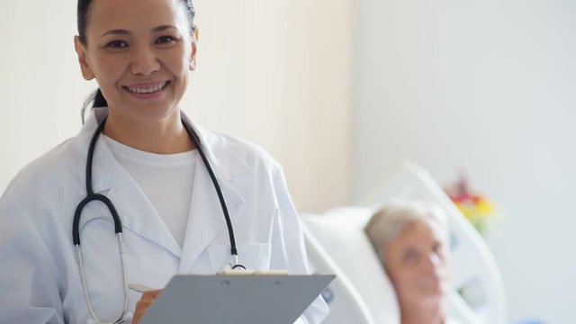 Cheerful adul female doctor standing in the hospital ward