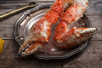 Fresh crab claws on vintage wooden background. Composition with copy space