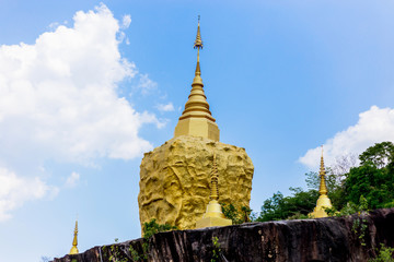 Naklejka premium golden pagoda and golden stone at wat tham pha daen in sakon nakhon thailand.