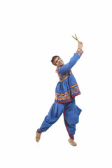 Portrait of happy young man in traditional clothes performing Dandiya Raas against white background