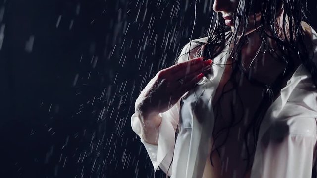 close-up. wet sexy girl with big silicone Breasts in a white unbuttoned shirt. gentle touching her delicate hand in the chest area and protruding from the cold nipple