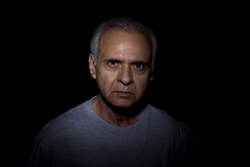 Portrait of serious man over black background 