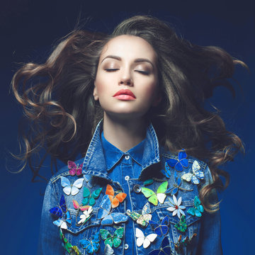 Young woman in jeans with a lot of brooches