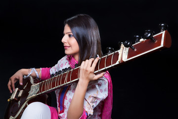 Obraz premium Young woman playing the sitar