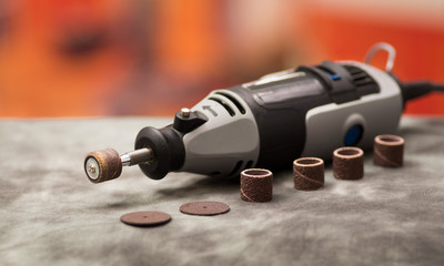 Obraz premium A gray drill with drilling accessories on gray background