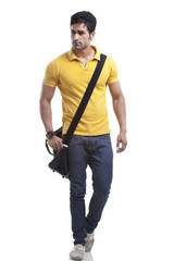 Naklejka premium Young man walking over white background 