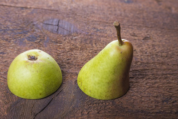 The sweet pears fruit cut in half on wooden board