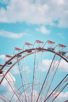 Retro toned picture of a Ferris wheel against blue sky.