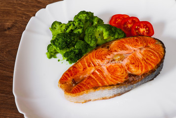 Salmon steak fillet with broccoli on plate