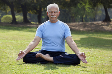 Senior man meditating in park 