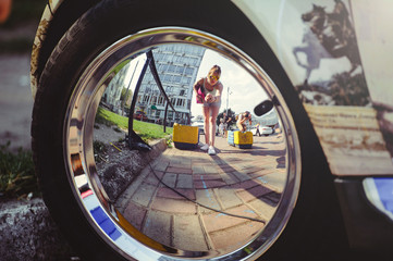  reflection of a woman in a chrome car wheel