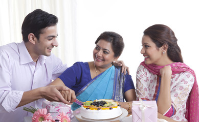 Woman cutting birthday cake with a knife