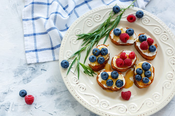Delicious crostini with ricotta, berries and honey.