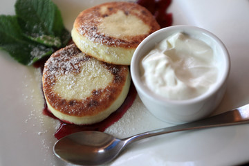 Syrniki with cream and jam