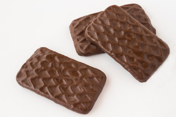 Cookies covered with icing of dark chocolate on a white background.