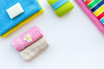 Preparing to take bath. Towels and soap on white background top view copyspace