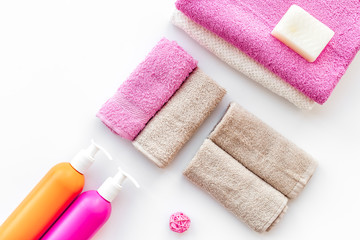 Obraz na płótnie Canvas Preparing to take bath. Towels, shampoo, hair conditioner, soap on white background top view copyspace