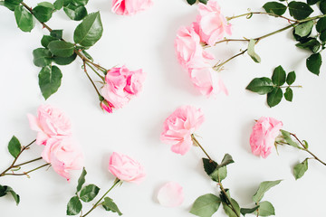 Floral pattern made of pink roses, green leaves on white background. Flat lay, top view. Floral pattern. Pattern of flowers. Flowers texture.