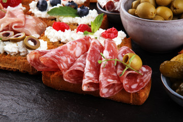 Italian antipasti wine snacks set. Cheese variety, Mediterranean olives, pickles, Prosciutto di Parma, tomatoes and wine in glasses. Spanish tapas