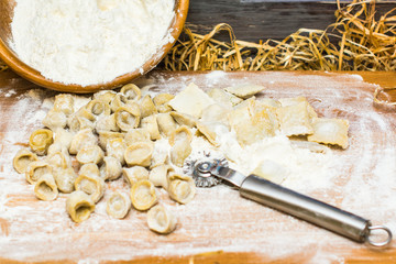 Italian ravioli on a wooden vintage wooden board, sprinkled with flour. Ravioli homemade. Top view.