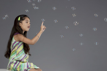 Girl trying to touch a bubble 