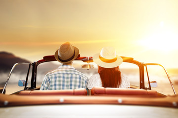 two lovers in retro car and golden sunset time 