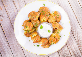 Smashed Potatoes with parsley and rosemary. View from above, top studio shot