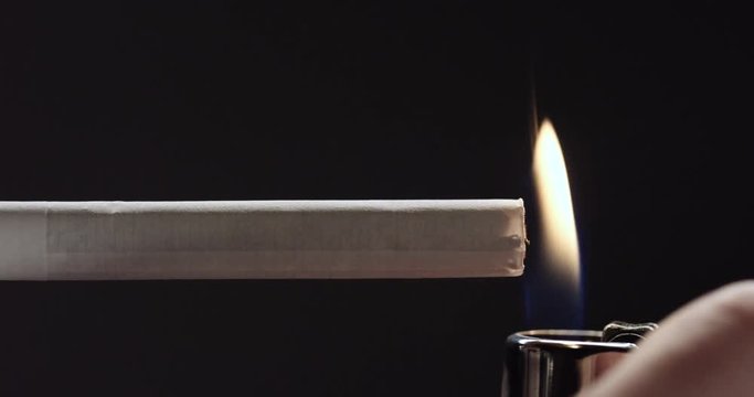 Person lights cigarette with lighter, close up