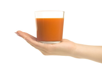 A glass of carrot-apple juice in a woman's hand