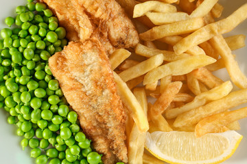 Plate of tasty fried fish and chips with peas, closeup